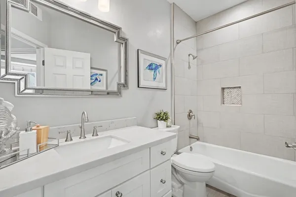 a bathroom with a granite countertop sink a toilet and a bathtub