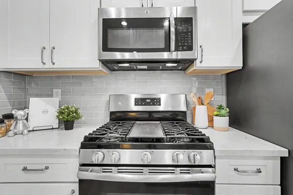 a stove top oven sitting inside of a kitchen