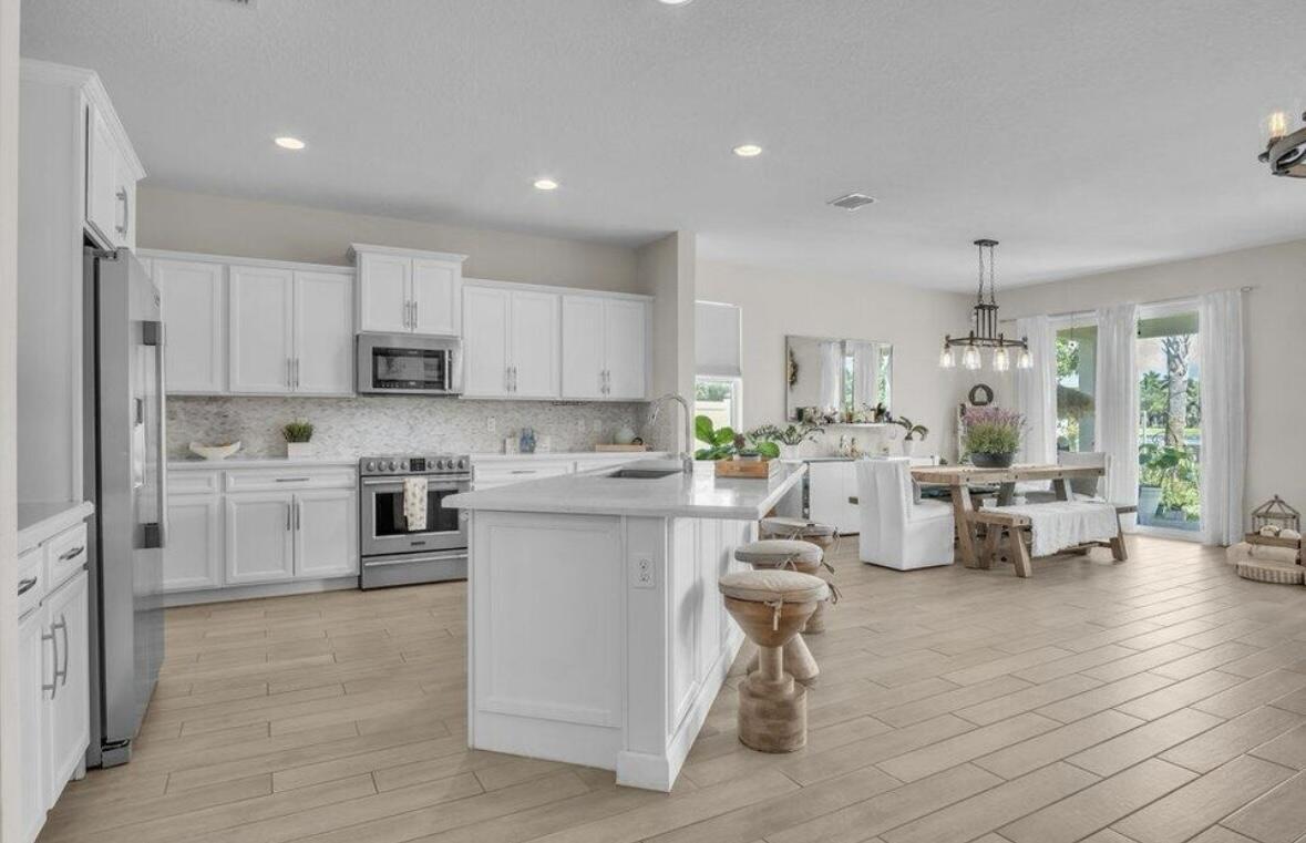 11971 Cypress Key Way Royal Palm Beach, FL 33411 - Photo 2 of 19 a open a kitchen with white cabinets and stainless steel appliances