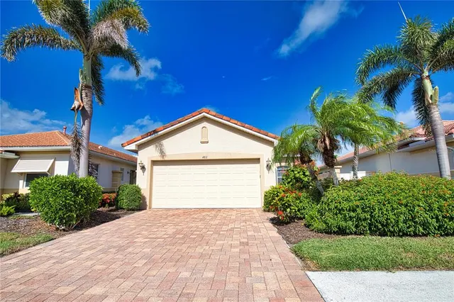 a front view of a house with a yard and potted plants