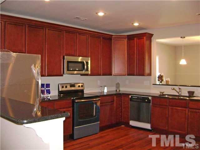 217 Camden Street Raleigh, NC 27601 - Photo 5 of 14 a kitchen with stainless steel appliances granite countertop a stove a sink dishwasher and a microwave oven with wooden cabinets