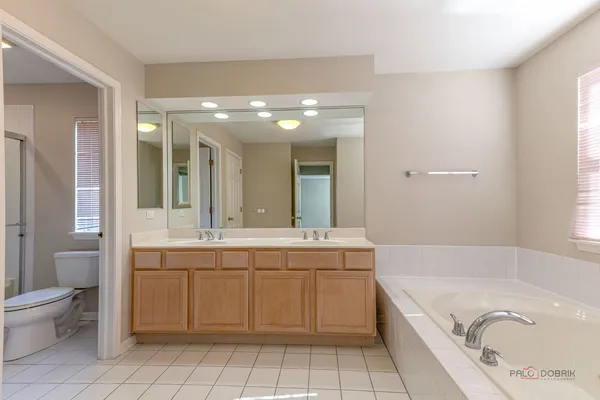 a spacious bathroom with a granite countertop tub sink and mirror