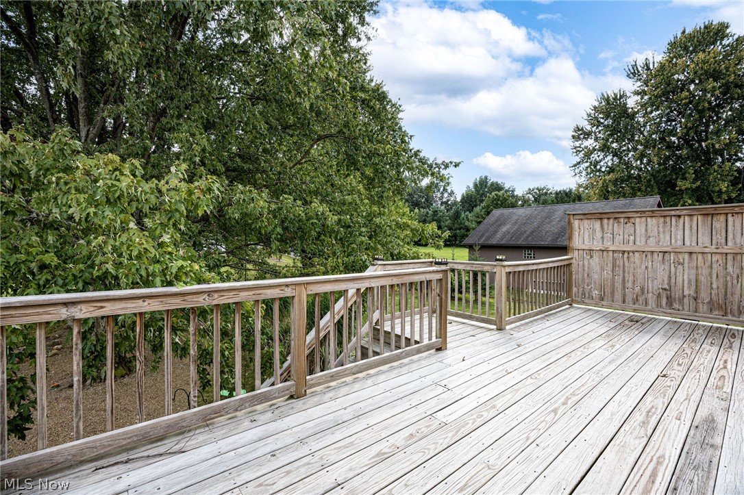 7996 Buffham Road Lodi, OH 44254 - Photo 5 of 40 Expansive outdoor deck with natural wood planking, wood railing, and privacy screen