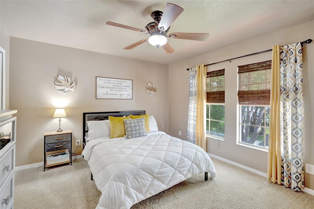 6932 Gray Catbird Loop Wesley Chapel, FL 33545 - Photo 13 of 25 a bedroom with a bed and a large window