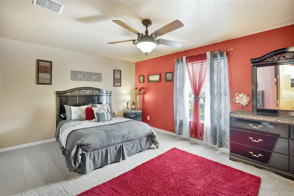 6932 Gray Catbird Loop Wesley Chapel, FL 33545 - Photo 15 of 25 a bedroom with a bed and a dresser