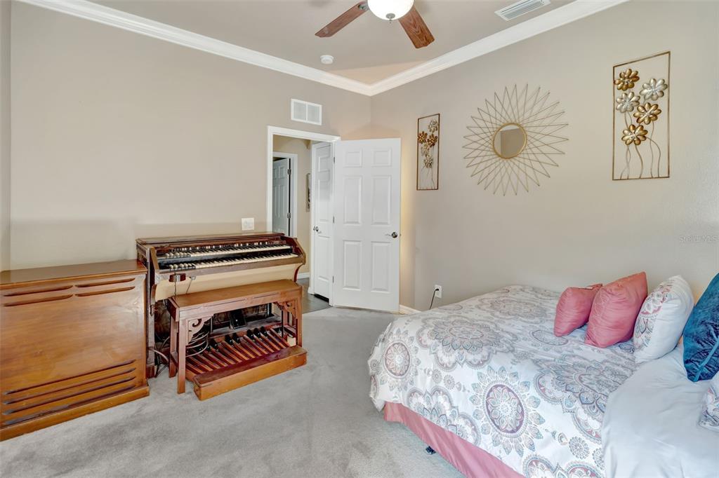 6932 Gray Catbird Loop Wesley Chapel, FL 33545 - Photo 19 of 25 a bedroom with a bed and a chandelier