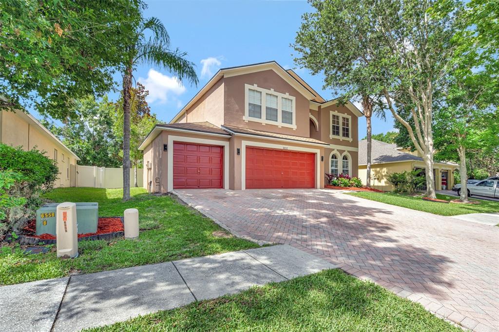 6932 Gray Catbird Loop Wesley Chapel, FL 33545 - Photo 2 of 25 a front view of a house with a yard and garage