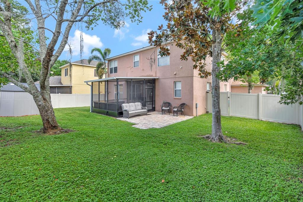 6932 Gray Catbird Loop Wesley Chapel, FL 33545 - Photo 24 of 25 a view of a house with backyard and a tree