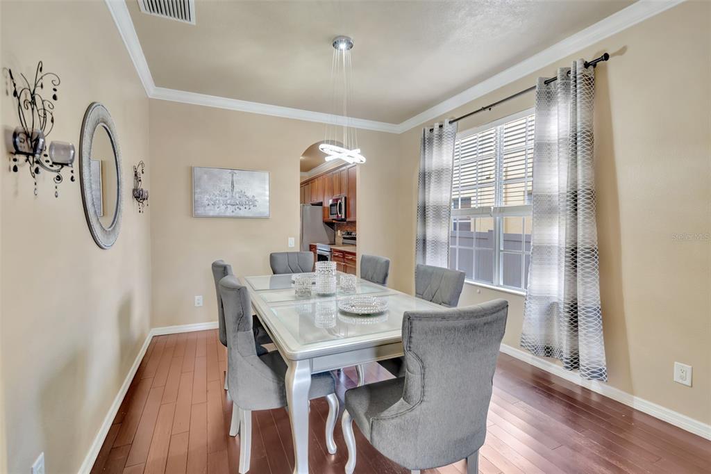 6932 Gray Catbird Loop Wesley Chapel, FL 33545 - Photo 6 of 25 a view of a dining room with furniture window and wooden floor