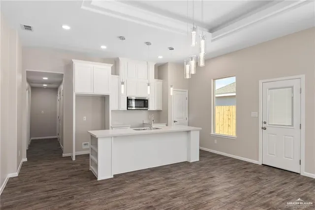 a view of a kitchen with a sink cabinets and wooden floor