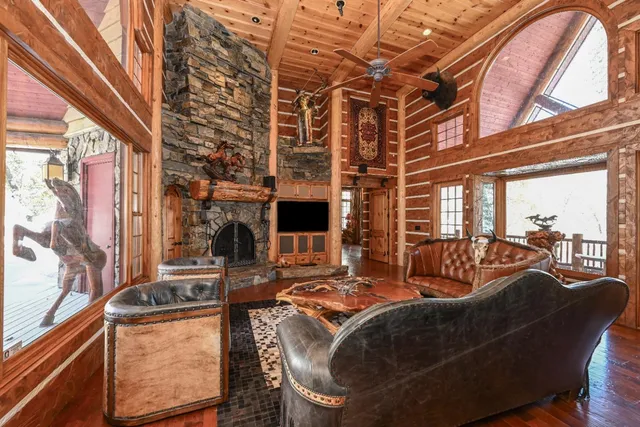 a living room with furniture a fireplace and wooden floor