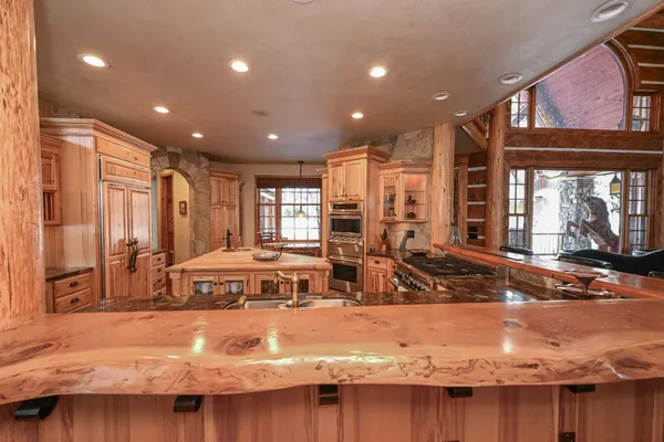 a kitchen with stainless steel appliances granite countertop a stove and a large window