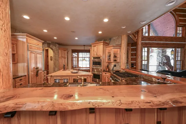 a kitchen with stainless steel appliances granite countertop a stove and a large window