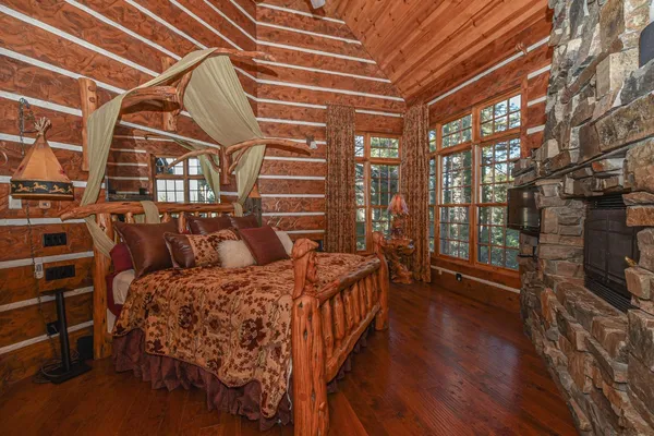 a bedroom with a bed a table and wooden floor