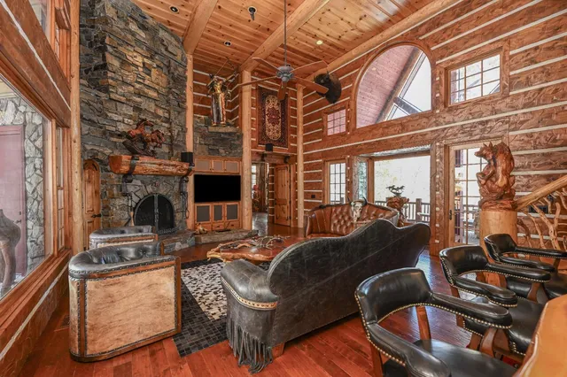 a living room with furniture a fireplace and large windows