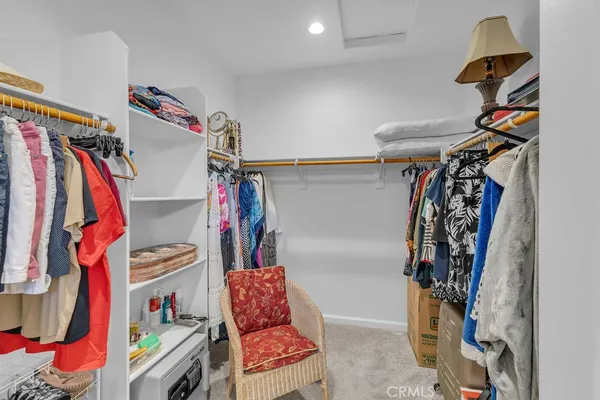 a view of walk in closet with clothes and shoes