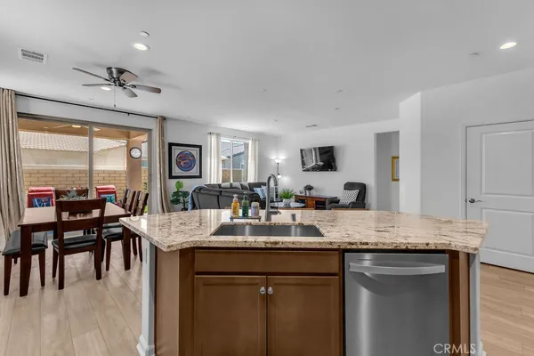 a kitchen with a granite countertop sink cabinets and refrigerator