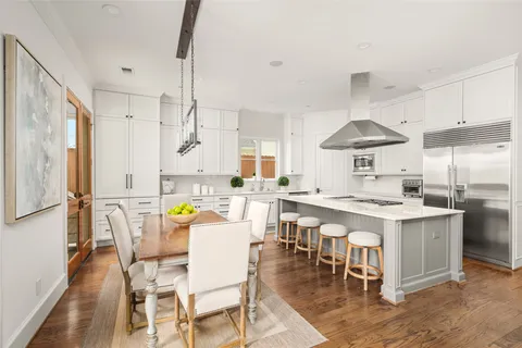 a kitchen with stainless steel appliances a table chairs and a chandelier