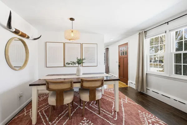 a view of a a dining room with furniture window and wooden floor