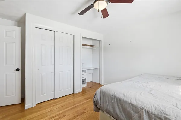 a bedroom with a bed and a ceiling fan