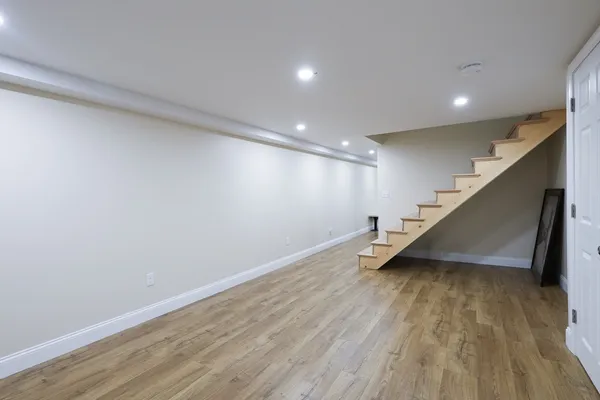 a view of an empty room with wooden floor