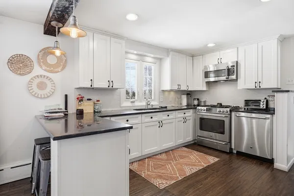 a kitchen with granite countertop white cabinets and white appliances