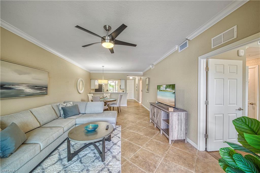 9560 Trevi Court, Unit 4815 Naples, FL 34113 - Photo 14 of 38 a living room with furniture and a large window