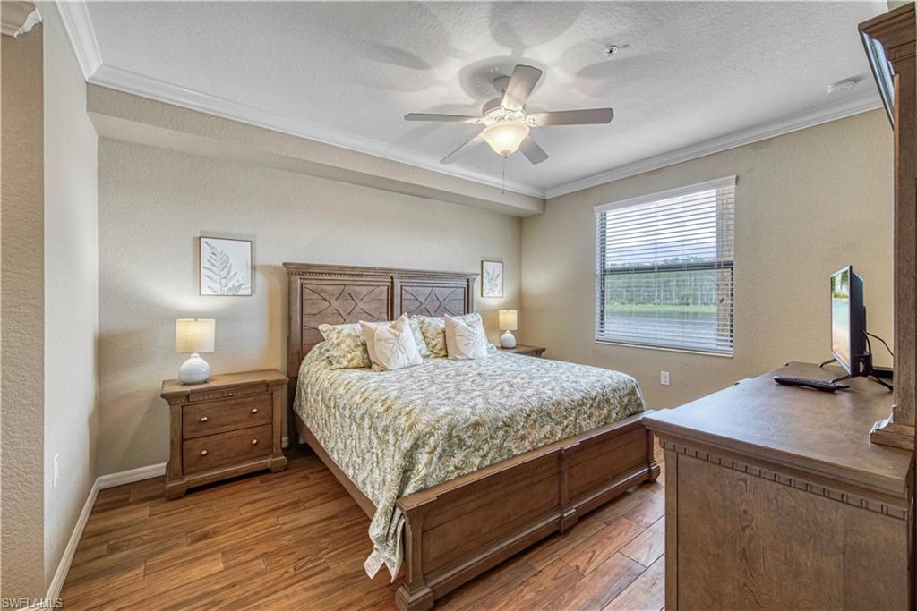 9560 Trevi Court, Unit 4815 Naples, FL 34113 - Photo 16 of 38 a bedroom with a bed and a table