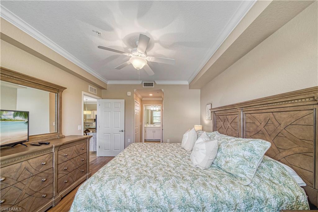 9560 Trevi Court, Unit 4815 Naples, FL 34113 - Photo 18 of 38 a spacious bedroom with a large bed and a chandelier