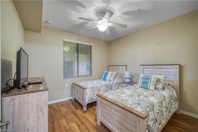 a bedroom with a bed and a flat tv screen on a dresser