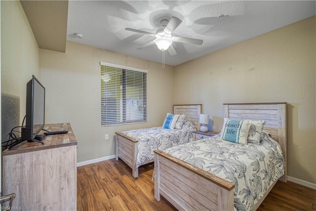 9560 Trevi Court, Unit 4815 Naples, FL 34113 - Photo 20 of 38 a bedroom with a bed and a flat tv screen on a dresser