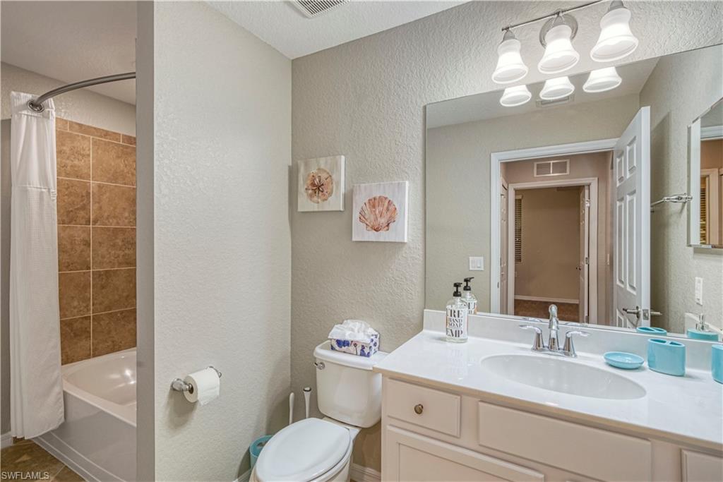 9560 Trevi Court, Unit 4815 Naples, FL 34113 - Photo 22 of 38 a bathroom with a granite countertop sink mirror vanity and toilet