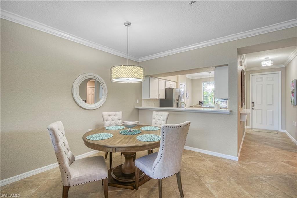 9560 Trevi Court, Unit 4815 Naples, FL 34113 - Photo 4 of 38 a view of a dining room with furniture a chandelier and wooden floor