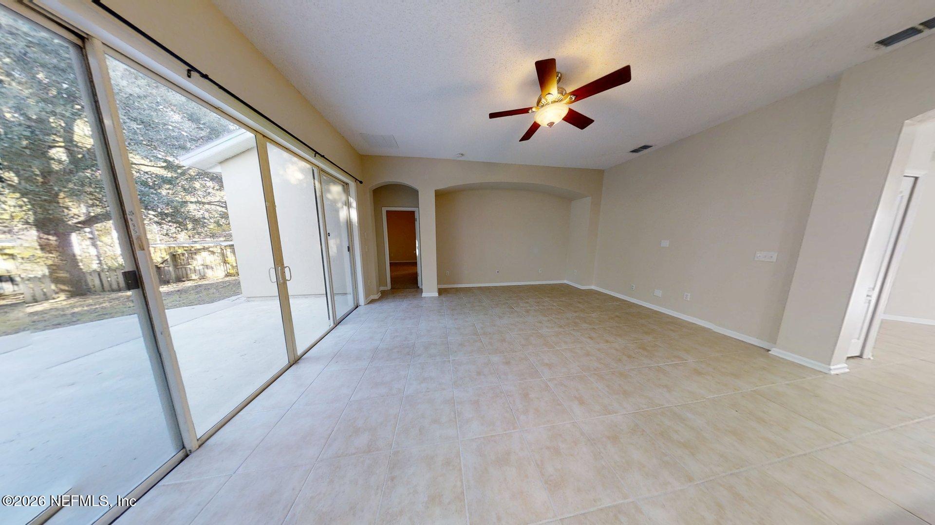 14454 Millhopper Road Jacksonville, FL 32258 - Photo 16 of 44 an empty room with ceiling fan and windows