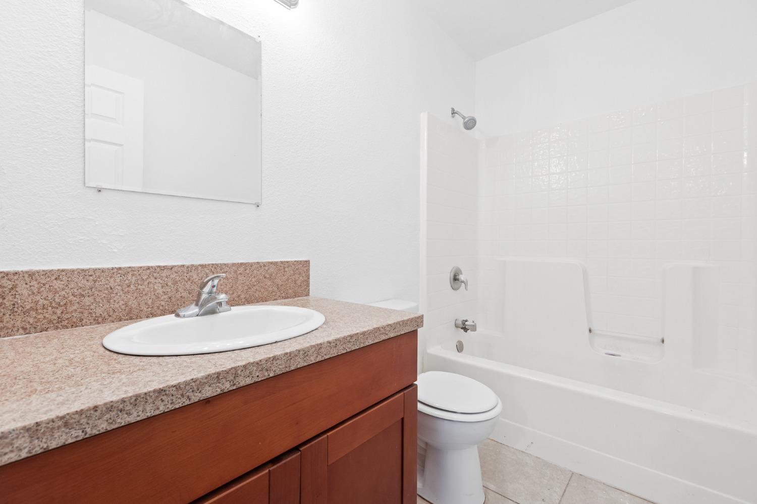 2242 Harvard Avenue Clovis, CA 93612 - Photo 23 of 34 a bathroom with a sink a toilet and shower