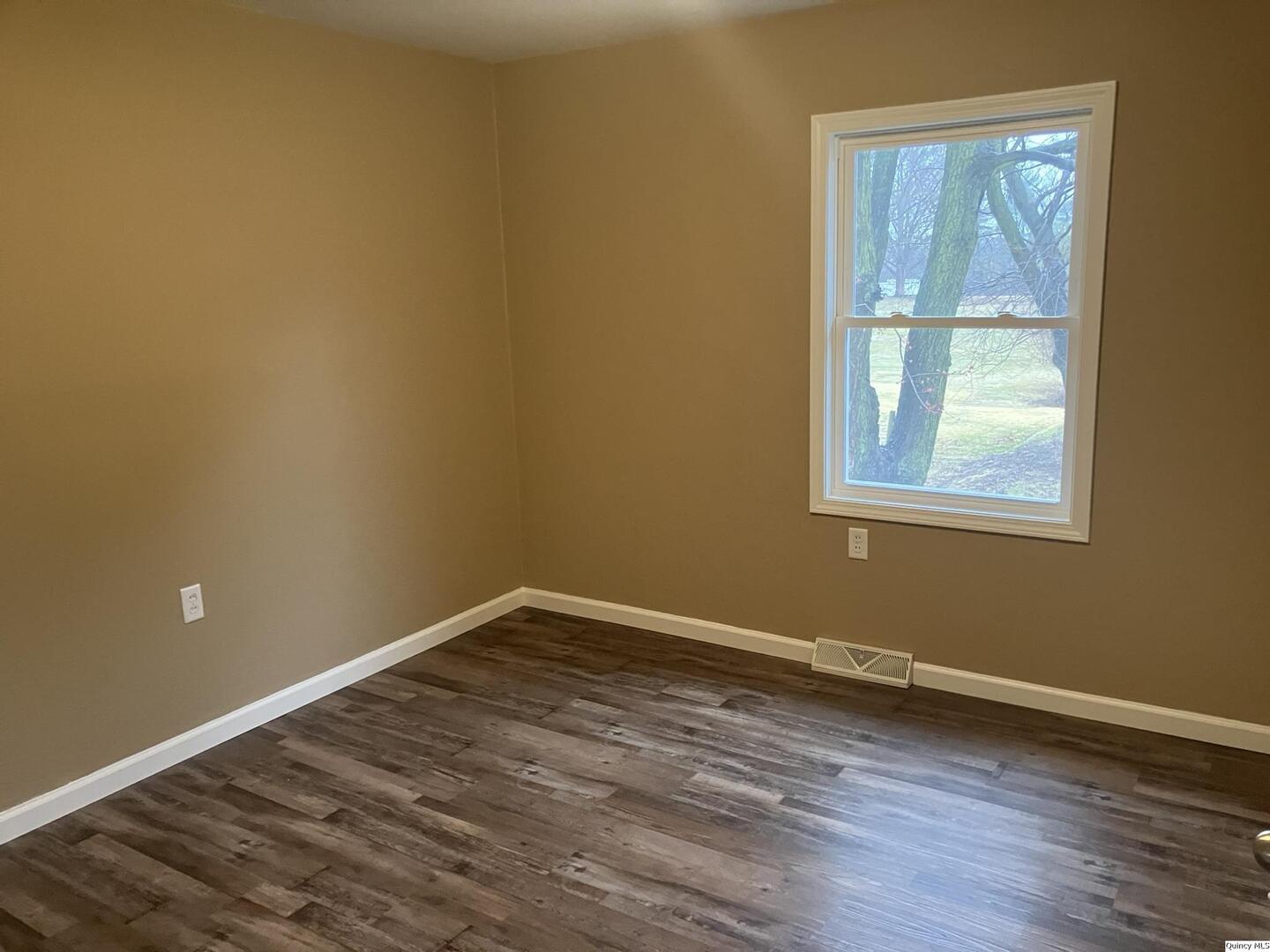 2525 Larch Road Quincy, IL 62301 - Photo 11 of 21 a view of an empty room with wooden floor and a window