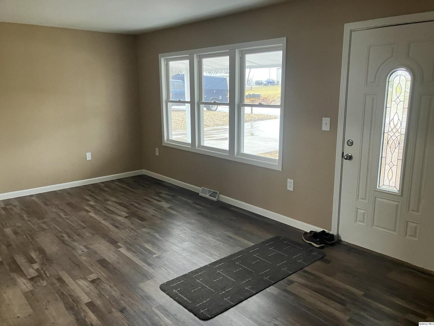 2525 Larch Road Quincy, IL 62301 - Photo 2 of 21 an empty room with wooden floor and windows