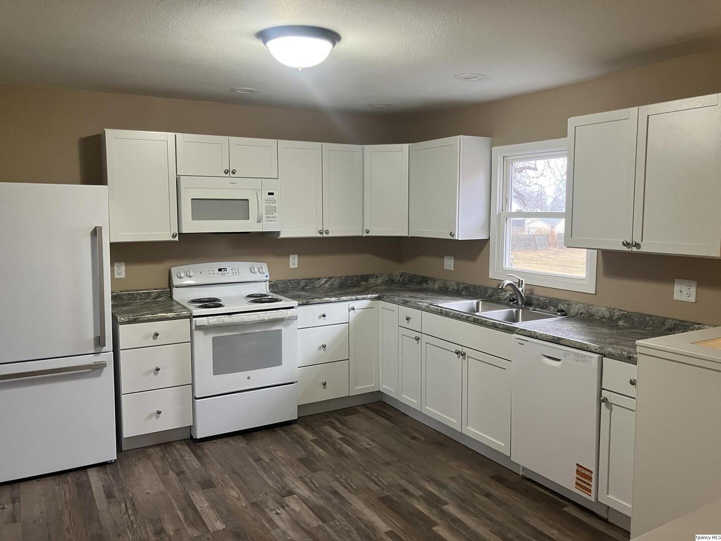 2525 Larch Road Quincy, IL 62301 - Photo 3 of 21 a kitchen with granite countertop white cabinets and white appliances