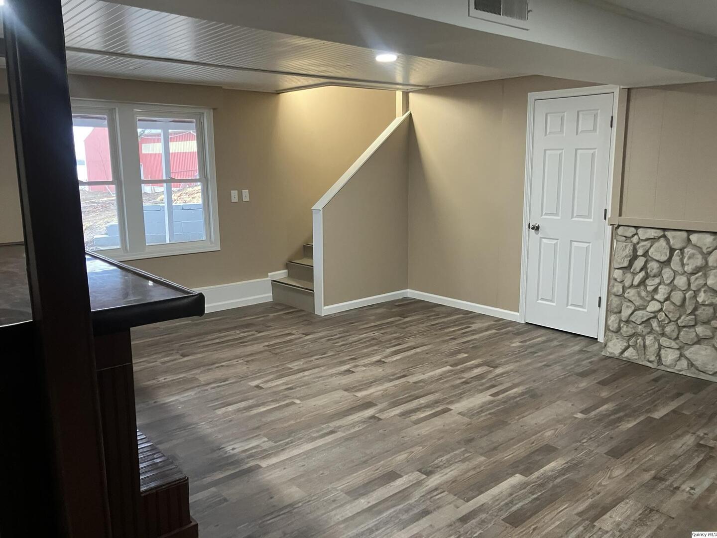 2525 Larch Road Quincy, IL 62301 - Photo 4 of 21 a view of an empty room with wooden floor and a window