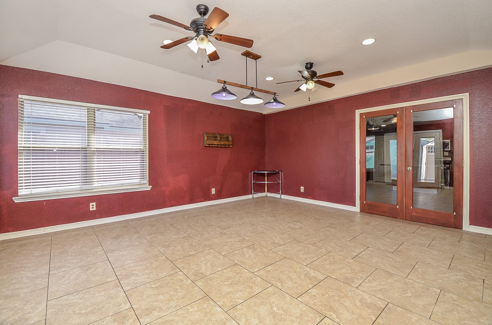 5411 Rio Drive Baytown, TX 77521 - Photo 13 of 30 With tiled flooring, burgundy walls, natural light, two ceiling fans and glass double doors, this area has the potential for multiple uses.