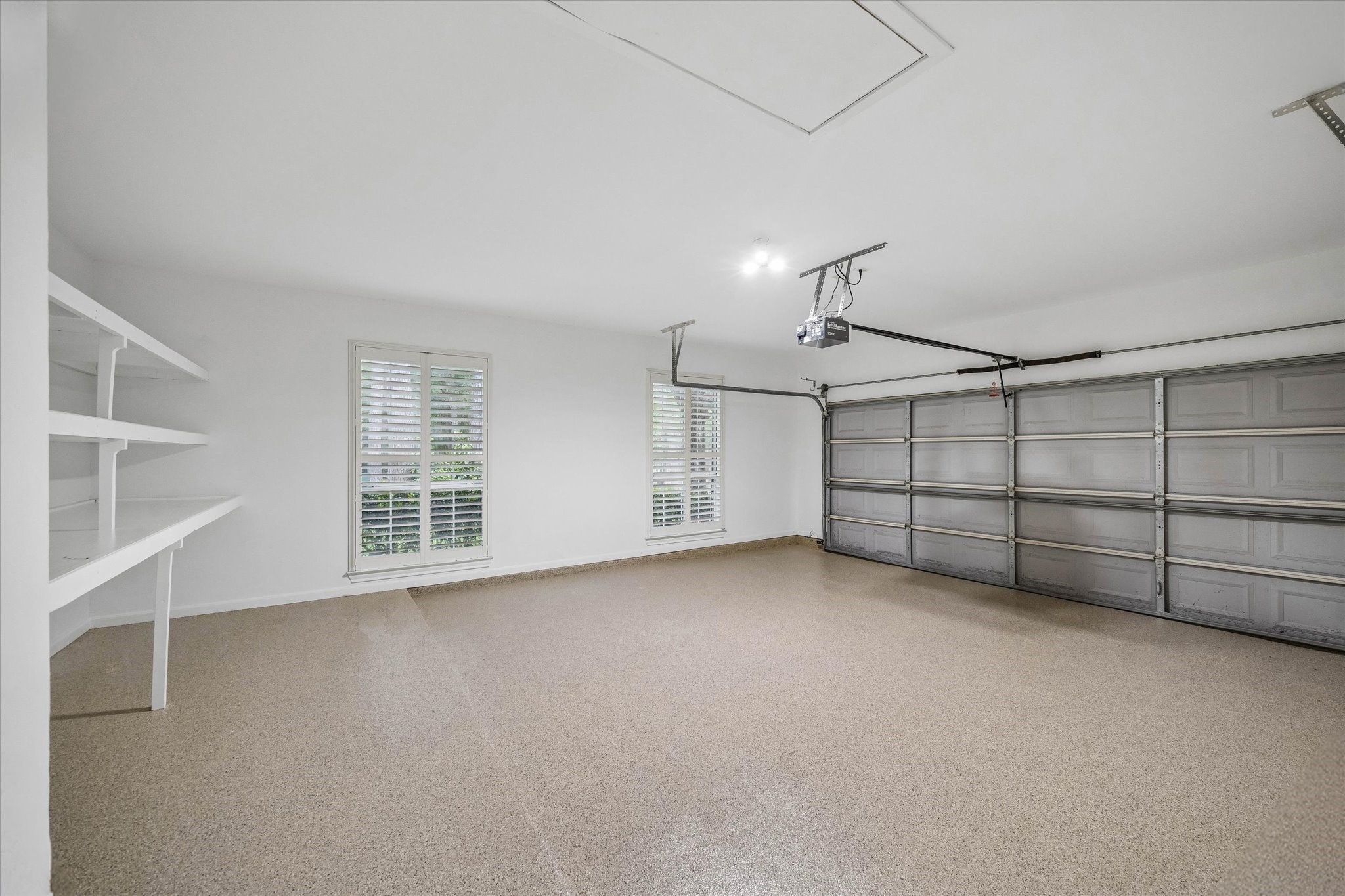 14530 Millhouse Road Pinehurst, TX 77362 - Photo 38 of 46 Alternate view of the spacious 3-car garage with recently installed epoxy flooring, built-in shelving, and abundant natural light.