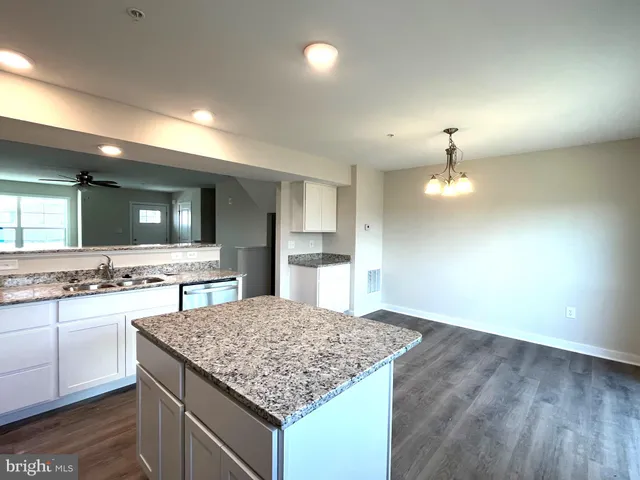 a kitchen with kitchen island a sink stove and refrigerator