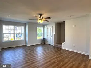 an empty room with wooden floor and window