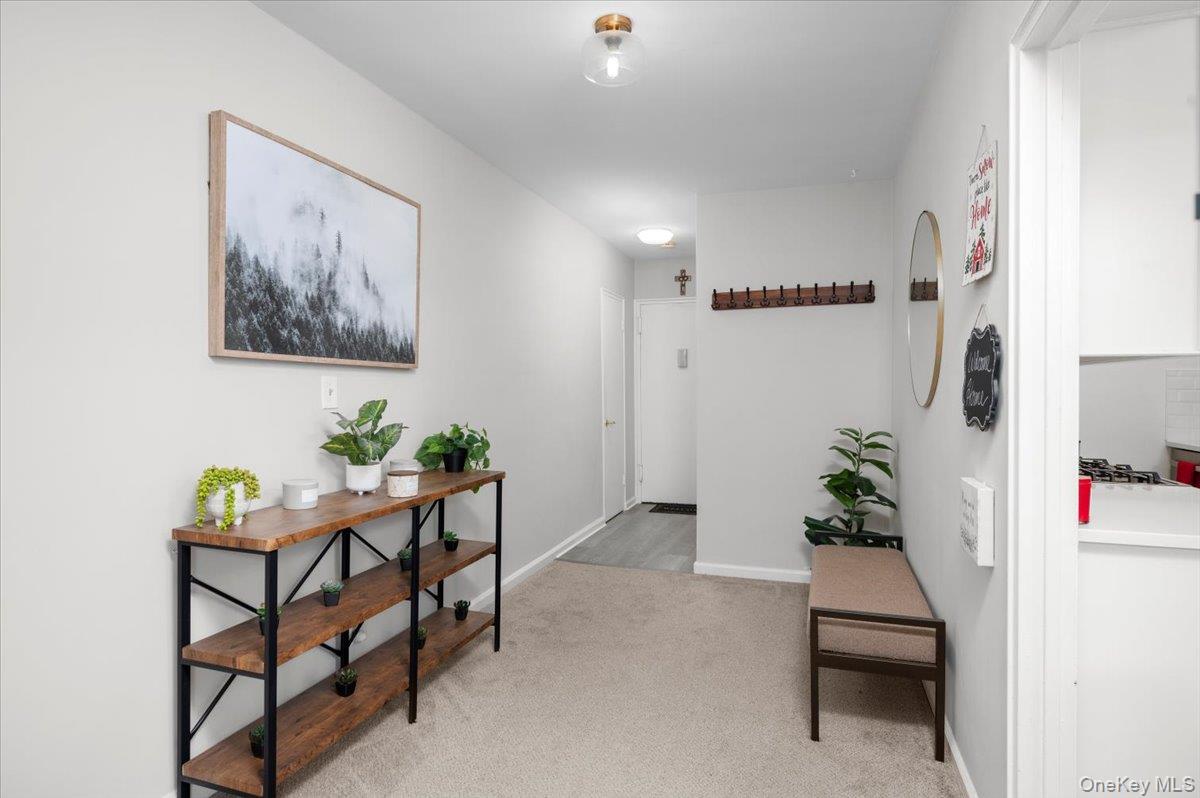 13 Bryant Crescent, Unit 2K White Plains, NY 10605 - Photo 4 of 29 a hallway with a dining table and chairs
