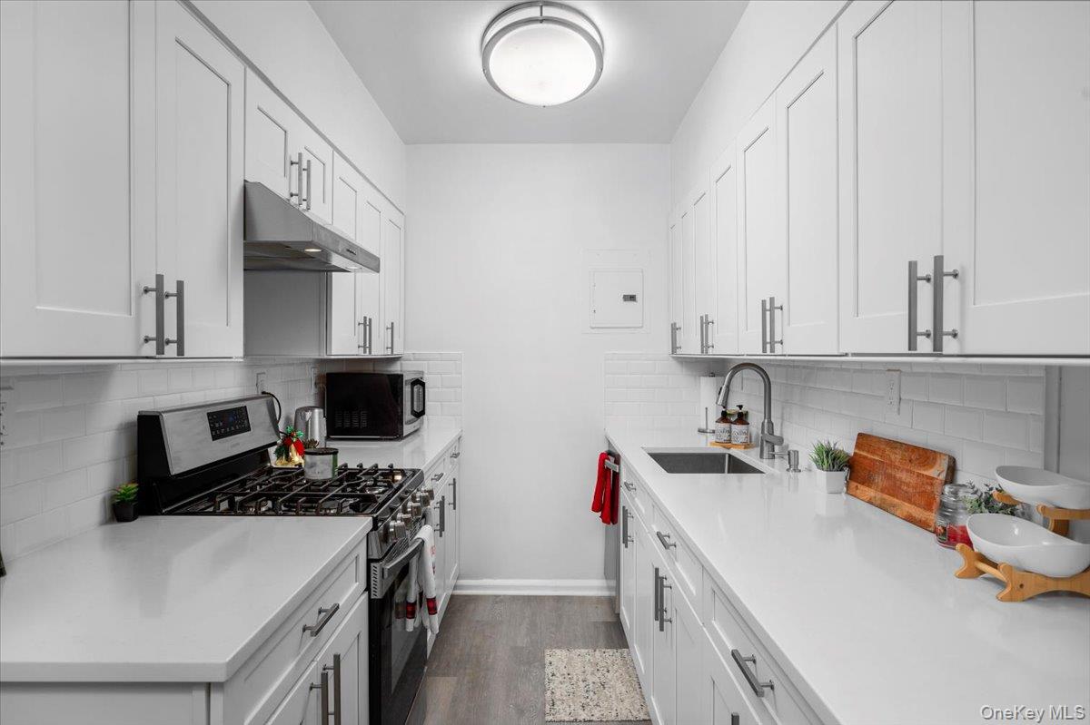 13 Bryant Crescent, Unit 2K White Plains, NY 10605 - Photo 7 of 29 a kitchen with stainless steel appliances a sink stove top oven and cabinets