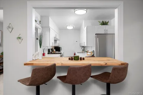 a kitchen with stainless steel appliances a sink a table and chairs