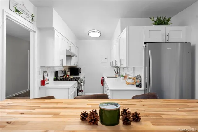 a kitchen with stainless steel appliances a refrigerator and a stove top oven