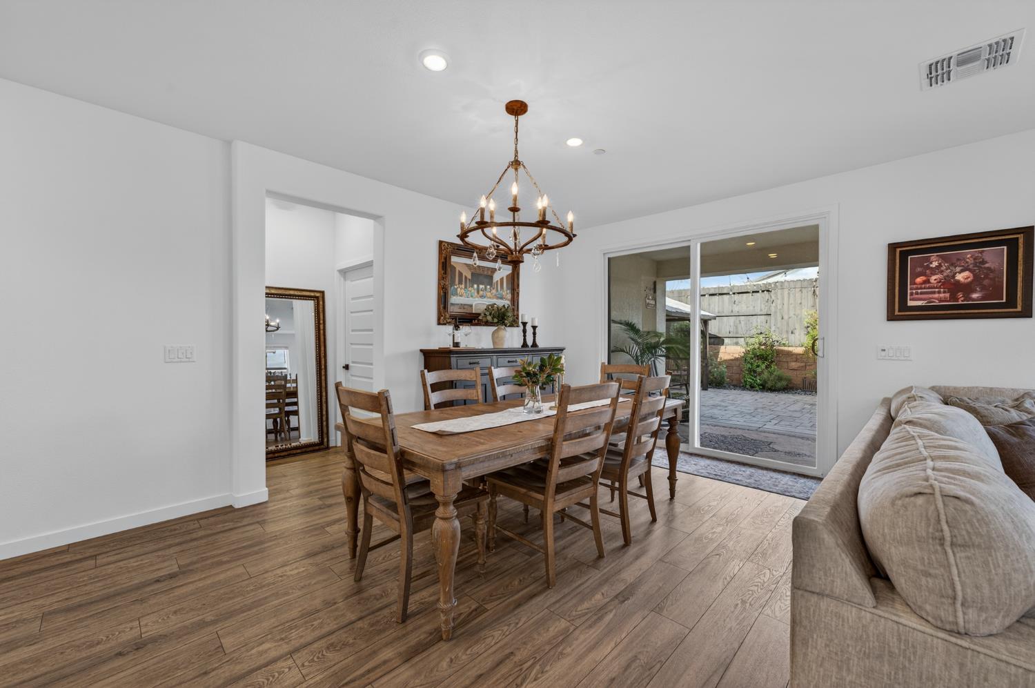 4498 Duckhawk Circle Rancho Cordova, CA 95742 - Photo 11 of 61 a dining room with wooden floor a chandelier a wooden table and chairs