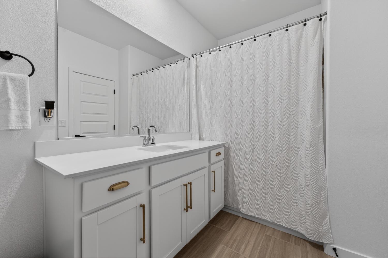 4498 Duckhawk Circle Rancho Cordova, CA 95742 - Photo 43 of 61 a bathroom with a granite countertop sink a mirror and a shower