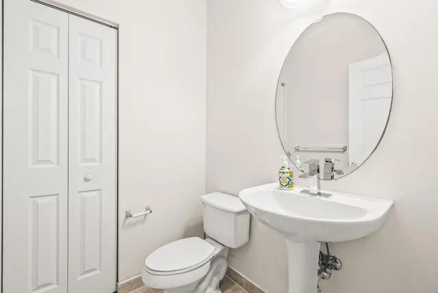 a bathroom with a sink a toilet and a mirror